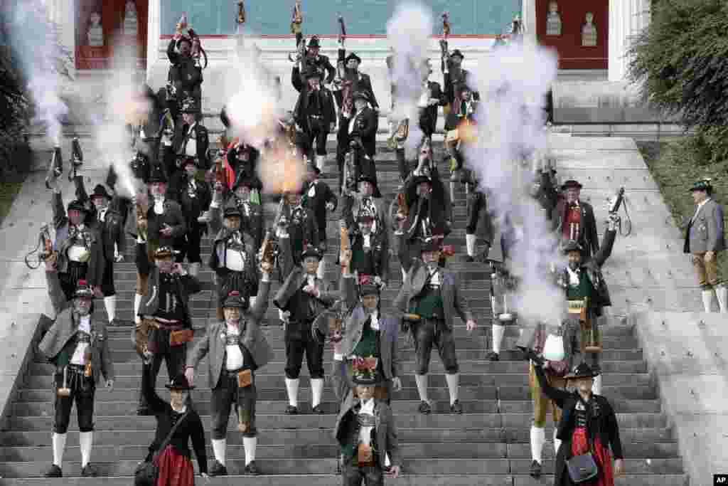 Bavarian riflemen and riflewomen in traditional costumes fire their muzzle loaders in front of the 'Bavaria' statue on the last day at the 183rd Oktoberfest beer festival in Munich, Germany, Oct. 3, 2016.