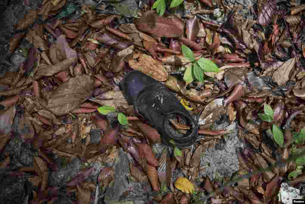 Pakaian ditemukan dekat kamp perdagangan manusia yang ditelantarkan di hutan dekat perbatasan Thailand di Bukit Wang Burma, Malaysia utara (26/5). (Reuters/Damir Sagolj)