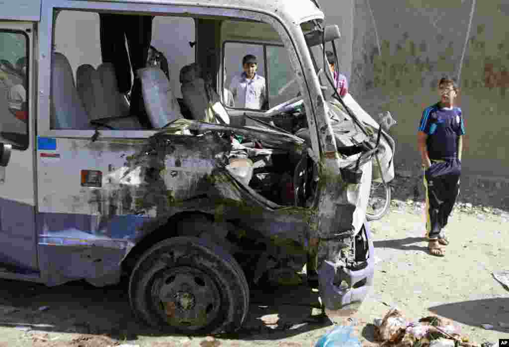 Children inspect a bus destroyed in a car bomb attack in the Shi'ite stronghold of Sadr City, Baghdad, March 19, 2013.