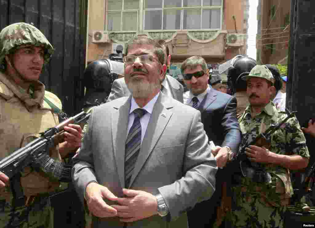 Islamic presidential candidate Mohamed Mursi arrives to a polling station to cast his vote in Al-Sharqya, 60 km (37 miles) northeast of Cairo, May 23, 2012.