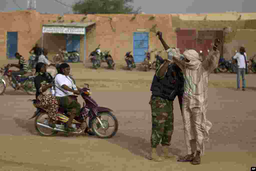 A man is patted down by a United Nations peacekeeper outside the main polling place in Kidal, Mali, July 28, 2013. 