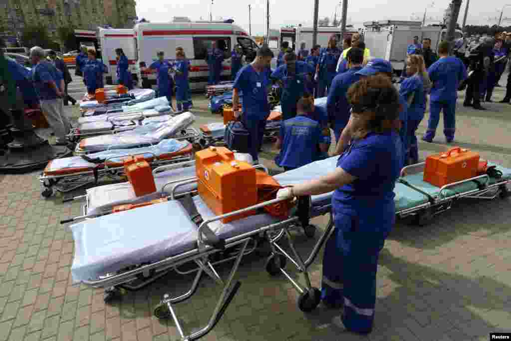 Para anggota tim layanan darurat menunggu di luar stasiun kereta menyusul kecelakaan di bawah tanah di Moskow (15/7). (Reuters/Sergei Karpukhin)