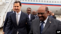 In this photo released by the Syrian official news agency SANA, Syrian President Bashar al-Assad, left, meets with Sudan's President Omar al-Bashir in Damascus, Syria, Dec. 16, 2018. 