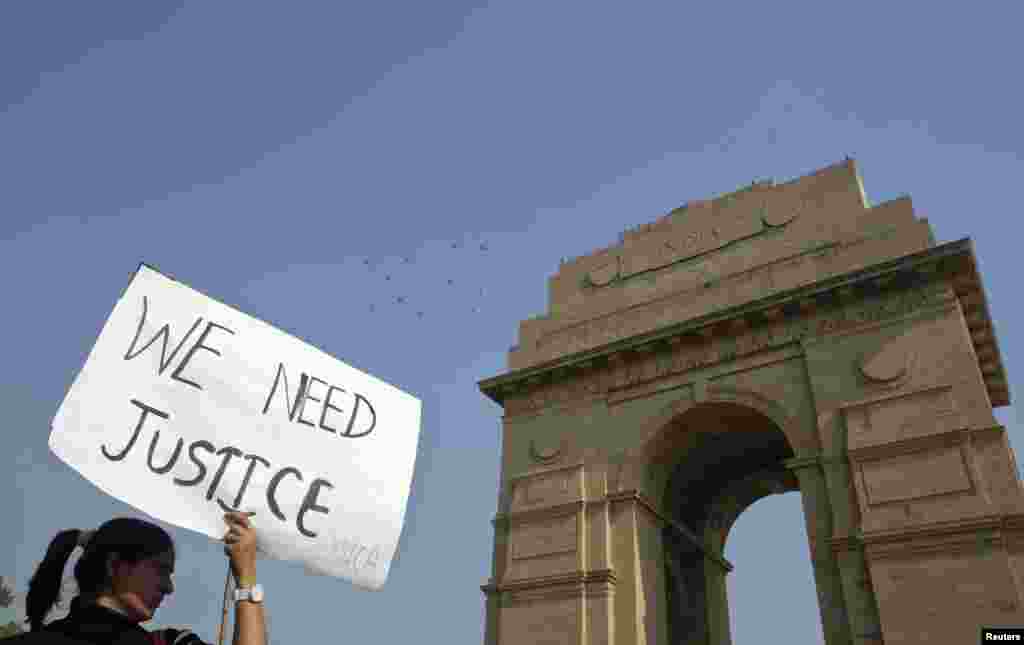 A demonstrator holds a placard in front of India Gate as she takes part in a protest rally organized by various women's organisations in New Delhi, India, December 21, 2012.