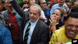 Former Brazilian President Luiz Inacio Lula da Silva, center left, is greeted by supporters as he arrives to the Federal Justice building in Curitiba, Brazil, May 10 2017. 