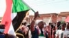 A Sudanese demonstrator waves a national flag as he shouts slogans during a rally against the military chief who launched an Oct. 25 coup followed by a bloody crackdown, in the northern part of Khartoum, Dec. 19, 2021.