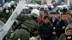 Riot police scuffle with migrants during a protest in Mytilene port on the northeastern Aegean island of Lesbos, Greece, on Tuesday, Feb. 4, 2020. Asylum seekers have demonstrated for a second day on the Greek island of Lesbos amid rising tension,…