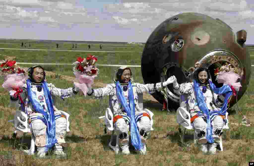 Astronot Cina, dari kiri: Zhang Xiaoguang, Nie Haisheng dan Wang Yaping tersenyum gembira setelah keluar dari kapsul antariksa Shenzhou 10 yang berhasil mendarat dengan sukses di lokasi pendaratan Siziwang Banner, di Mongolia, China utara.