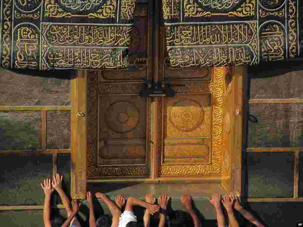 Para jamaah berdoa di pintu Ka'bah di Masjidil Haram, Mekkah, Arab Saudi.