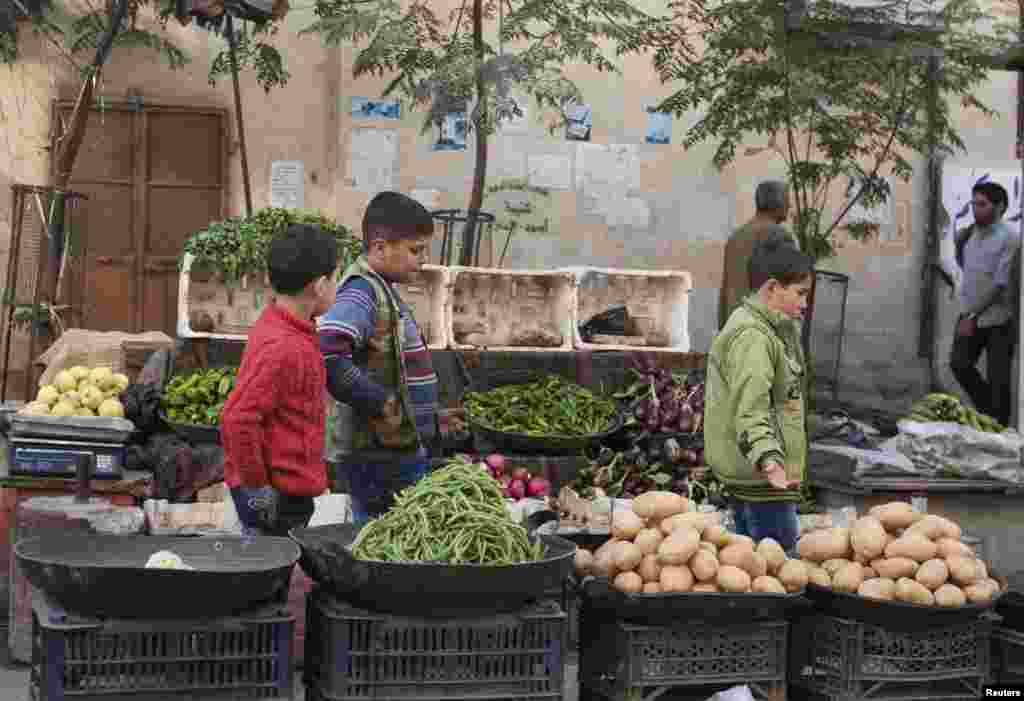 Boys pass by a vegetable stall in Aleppo, Oct. 21, 2013.