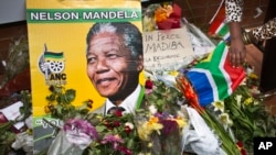 Flores, carteles y mensajes son dejados por los dolientes enfrente de la casa de Mandela en Soweto, Johannesburgo.