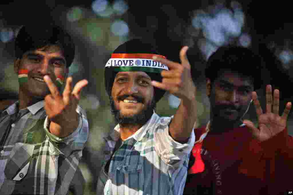 Indian cricket fans react to the camera as they line up to get inside the Chinnaswamy Stadium in Bangalore, India, December 25, 2012.