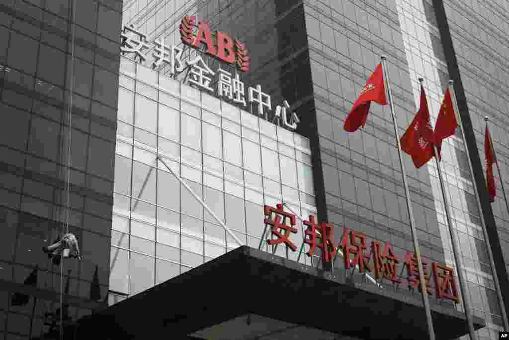 北京安邦保险集团大楼外面有人擦玻璃(2017年3月16日) 。 财新传媒的《新世纪》2015年2月2日发表文章《安邦大冒险》。报道说:“ 吴小晖有过三次婚姻,第二任为浙江省一位卢姓副省长之女,第三任妻子是在陈小鲁的公司标基投资集团工作时邂逅的卓苒——前国家领导人邓小平的外孙女、原中国科协党组书记邓楠之女,两人有一子,但目前夫妻关系已确认中止。2014年,因海外媒体多渲染安邦与邓家的关系,邓家曾小范围开会讨论过安邦的事宜,确认已与邓家无关。 ”后来安邦法律部声言要“起诉财新传媒……对公司董事长吴小晖进行人身攻击,捏造其‘有过三次婚姻’的不实报道,炮制其‘夫妻关系已确认中止’等谣言,……严重侵犯公司权益及吴小晖先生的名誉权。”