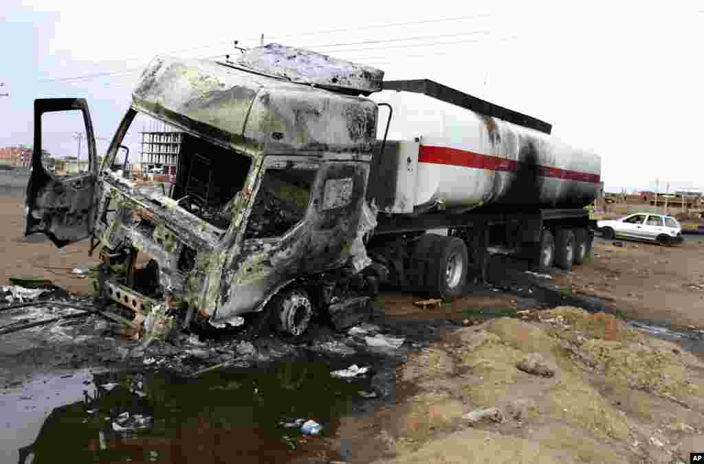 A destroyed fuel tanker is left behind after rioters torched a gas station in Khartoum, Sudan, Sept. 26, 2013.