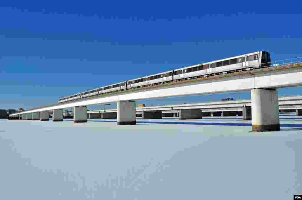 Kereta melewati jembatan di atas Sungai Potomac di Arlington, Virginia, di luar kota Washington DC yang permukaan airnya membeku menjadi es.