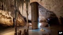 Engineer Guillermo D. Christy photographs a steel pillar filled with concrete that was installed inside the Aktun Tuyul cave system to support the Maya Train track on the outskirts of Playa del Carmen, Mexico, March 3, 2024. 
