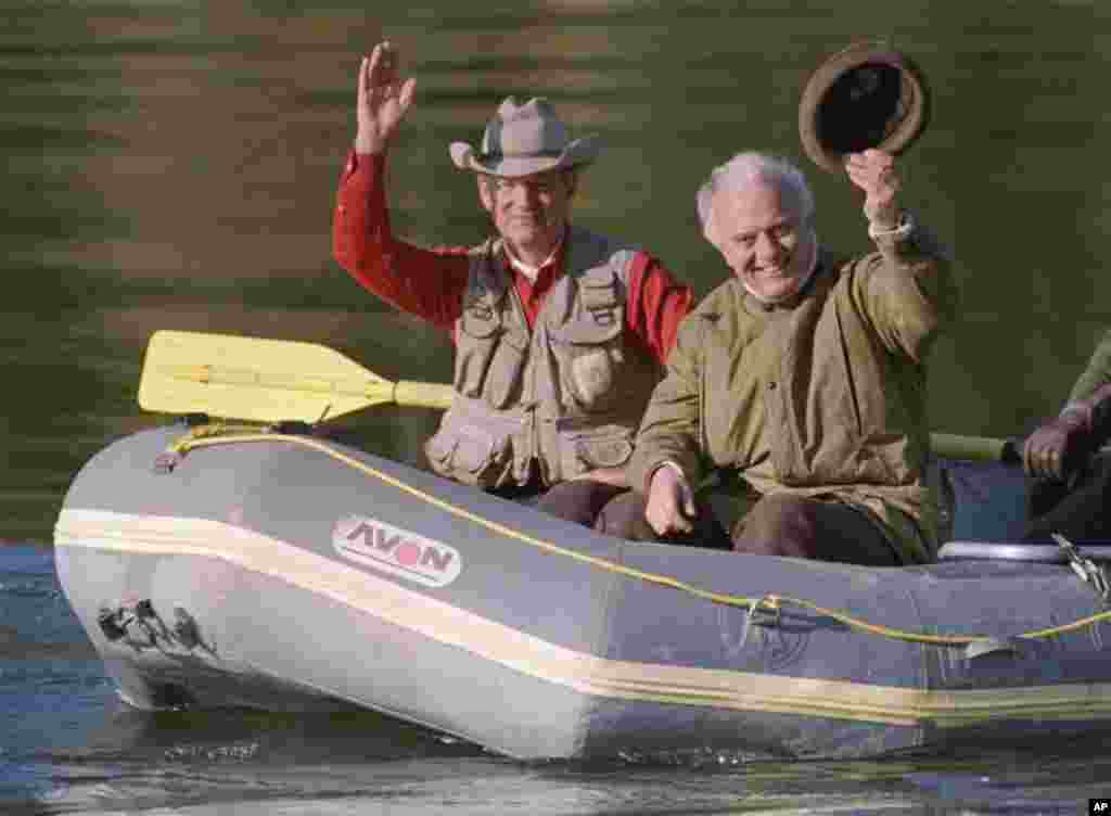 U.S. Secretary of State James Baker and Soviet Foreign Minister Eduard Shevardnadze wave from a rubber raft after they went fishing in Snake River, Wyoming, Sept. 24, 1989.