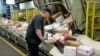A U.S. postal worker arranges packages on a conveyor belt at the main post office in Omaha, Nebraska, Dec. 14, 2017.
