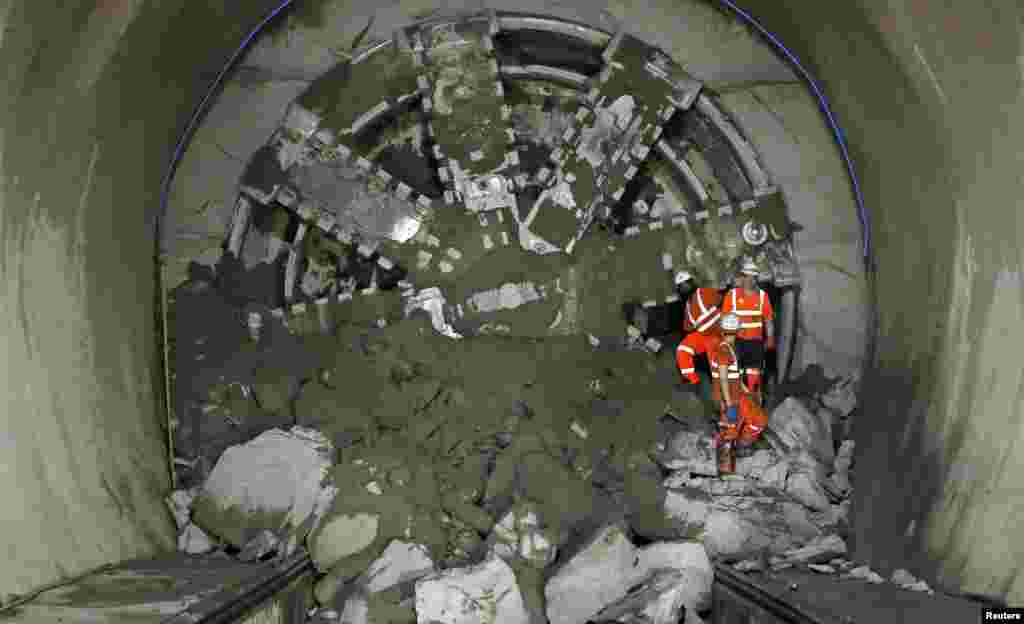 Crossrail workers climb out from "Victoria", a tunnel boring machine after breaking through at Whitechapel underground station in London. Crossrail is the largest infrastructure project in Europe and will provide a new link across London which is due to be completed in 2017.