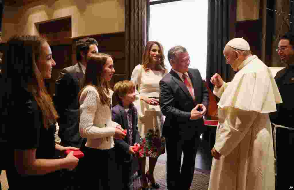 Jordan's King Abdullah, with his wife Queen Rania, talks with Pope Francis as their four children listen at the royal palace in Amman, May 24, 2014.