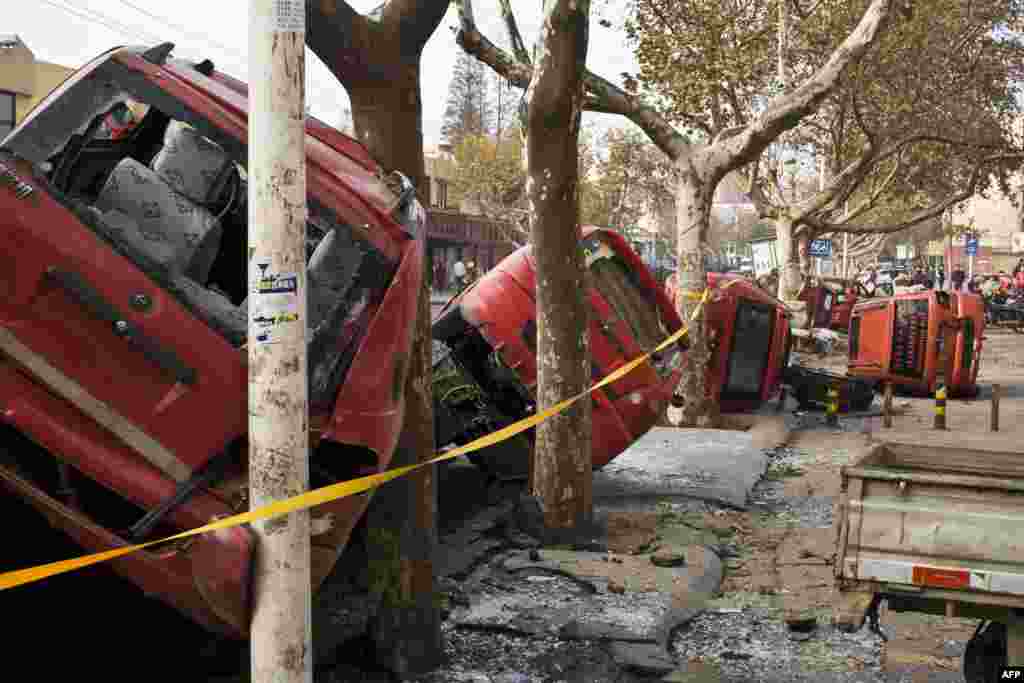 Damaged vehicles lie by a street after an oil pipeline exploded, killing at least 35 people, ripping roads apart, turning cars over and sending thick black smoke billowing over the city of Qingdao, east China's Shandong province.