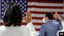 FILE- In this July 2, 2020, file photo, people take the oath of citizenship during a naturalization ceremony at U.S. Citizenship and Immigration Service's Field Office in New York.