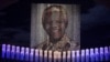 Candles are lit under a portrait of former South African President Nelson Mandela in his ancestral village of Qunu December 15, 2013.