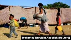Mwanamke kutoka Ethiopia akita na watoto wake wakiwasili katika kambi ya wakimbizi ya Um-Rakoba katika mpaka kati ya Ethiopia na Sudan, katika jimbo la Al-Qadarif, Sudan, wakikimbia vita katika Jimbo la Tigray, Ethiopia, Novemba 19, 2020. REUTERS/Mohamed Nureldin Abdallah
