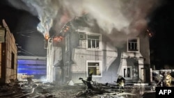 Tim penyelamat bekerja di sebelah gedung administrasi yang rusak akibat serangan pesawat tak berawak di wilayah Kyiv, 30 Januari 2024. (Handout/LAYANAN DARURAT UKRAINIAN/AFP)