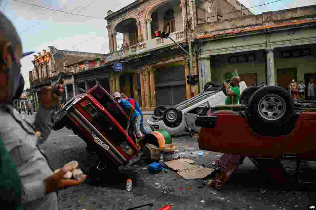 Police cars are seen overturned in the street in the framework of a demonstration against Cuban President Miguel Diaz-Canel in Havana, July 11, 2021.
