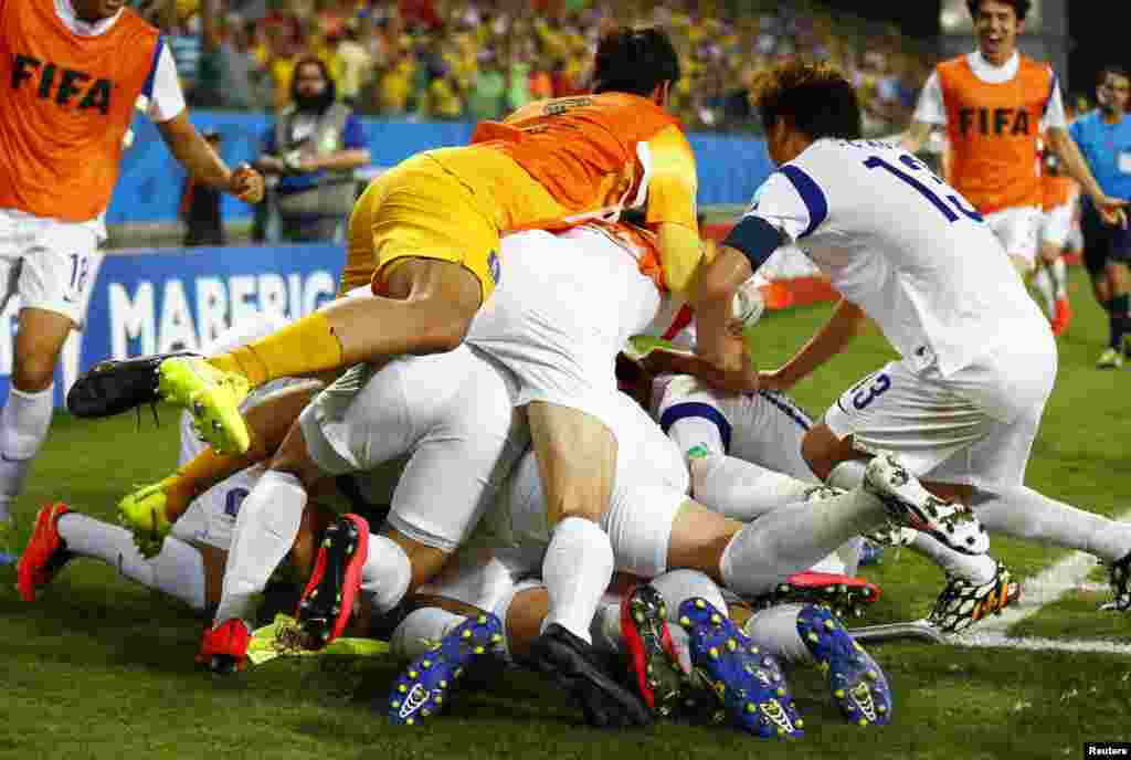 South's Korea's national soccer players pile on top of teammate Lee Keun-ho as they celebrate his goal against Russia during their 2014 World Cup Group H soccer match at the Pantanal arena, in Cuiaba, June 17, 2014.