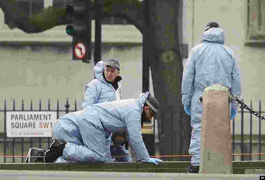 Police forensic officers work in Parliament Square outside the Houses of Parliament in London, March 23, 2017.