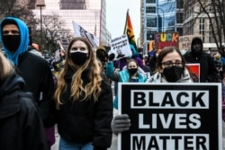 OOrang-orang membawa poster dan berkumpul di luar gedung pengadilan ketika persidangan mantan polisi Minneapolis yang didakwa membunuh George Floyd di Minneapolis, Minnesota, berlangsung.