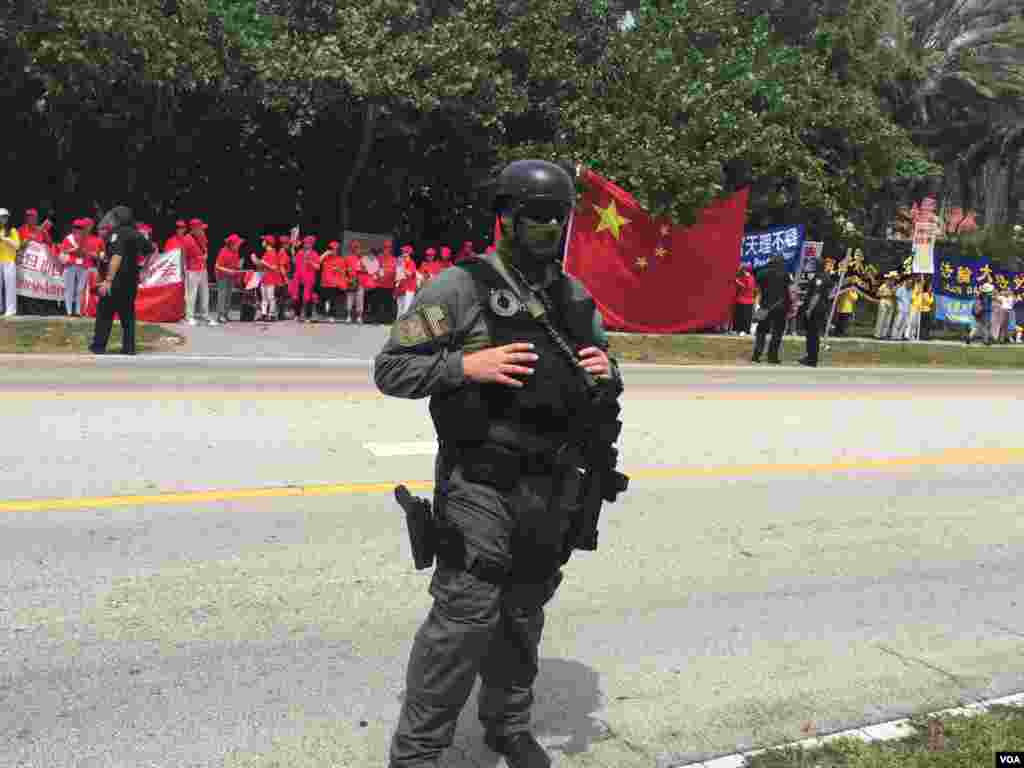 防爆警察與聚集在習近平下塌酒店附近的人群(美國之音莉雅拍攝)。這張圖片中有穿紅色上衣的歡迎習近平的人群,有人稱他們為紅衫軍,也有法輪功示威者。