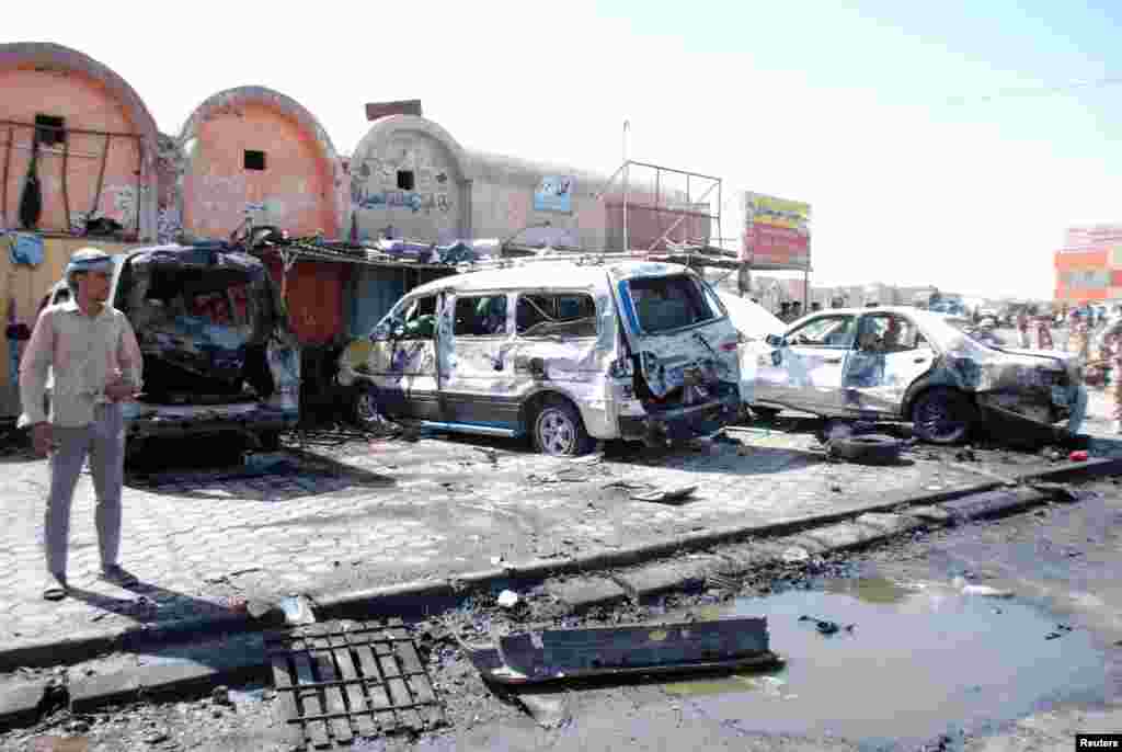 A man stands at the site of a car bomb attack in the city of Kut, southeast of Baghdad, July 29, 2013. 