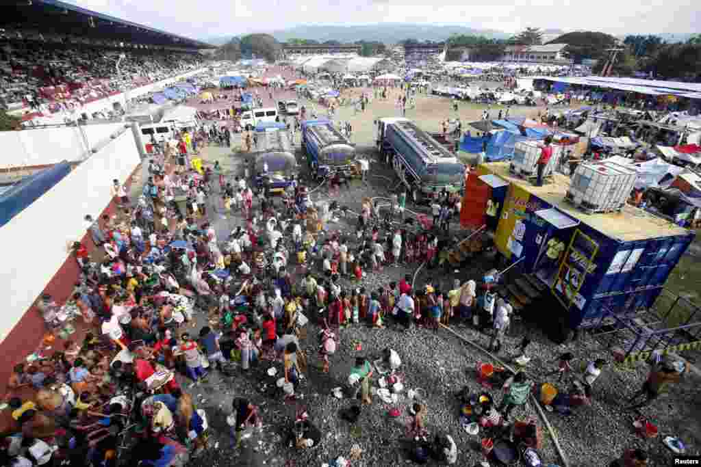 Residents line up for a shower in a stadium turned into an evacuation center in Zamboanga, Philippines, Sept. 18, 2013.
