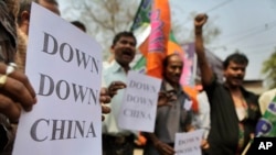 Indian activists shout slogans and hold placards during a protest in Guahati, India, Wednesday, March 21, 2012. The activists were protesting against the construction of dams in China in the middle reaches of the Brahmaputra River, or the Yarlung…