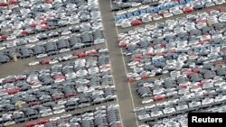 FILE - Cars for export stand in a parking area at a shipping terminal in the harbor of the northern German town of Bremerhaven, October 8, 2012. 
