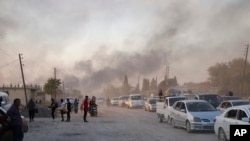 Syrians flee shelling by Turkish forces in Ras al Ayn, northeast Syria, Wednesday, Oct. 9, 2019.
