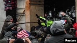 Demonstranti u okršaju sa policijom na zapadnom ulazu u Capitol, 6. januar 2021. 