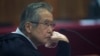 El expresidente de Perú Alberto Fujimori, es fotografiado a través de una ventana de vidrio, mientras asiste a su juicio en una base policial en las afueras de Lima, Perú, el 28 de junio de 2016. Archivo.