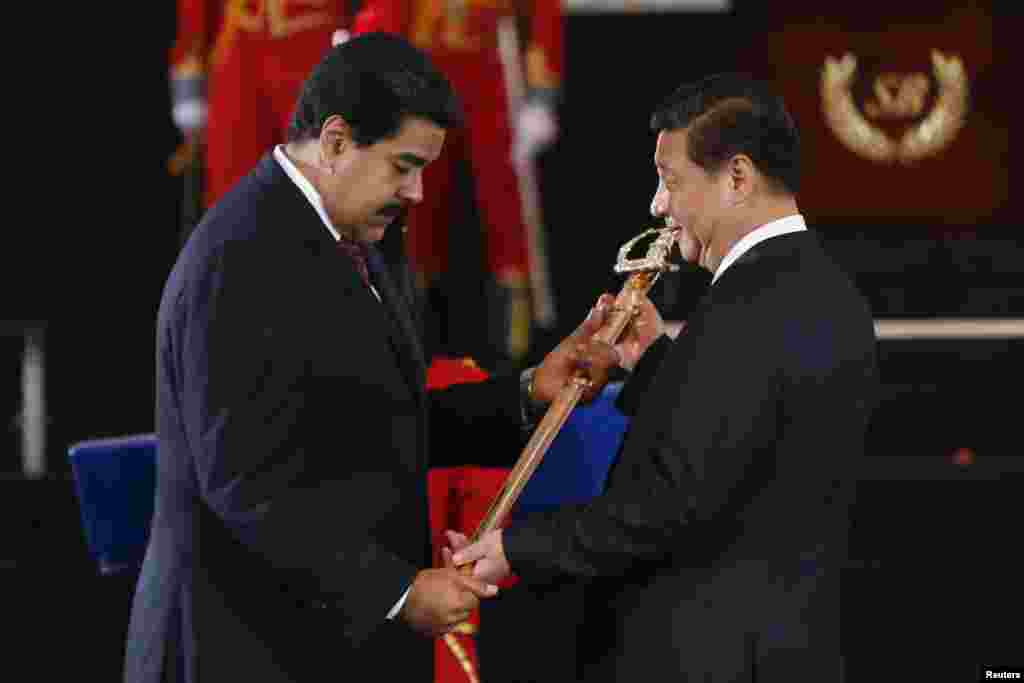 Venezuelan President Nicolas Maduro, left, presents Chinese President Xi Jinping with a replica of the sword of national hero Simon Bolivar during a ceremony at the National Pantheon in Caracas, July 20, 2014.