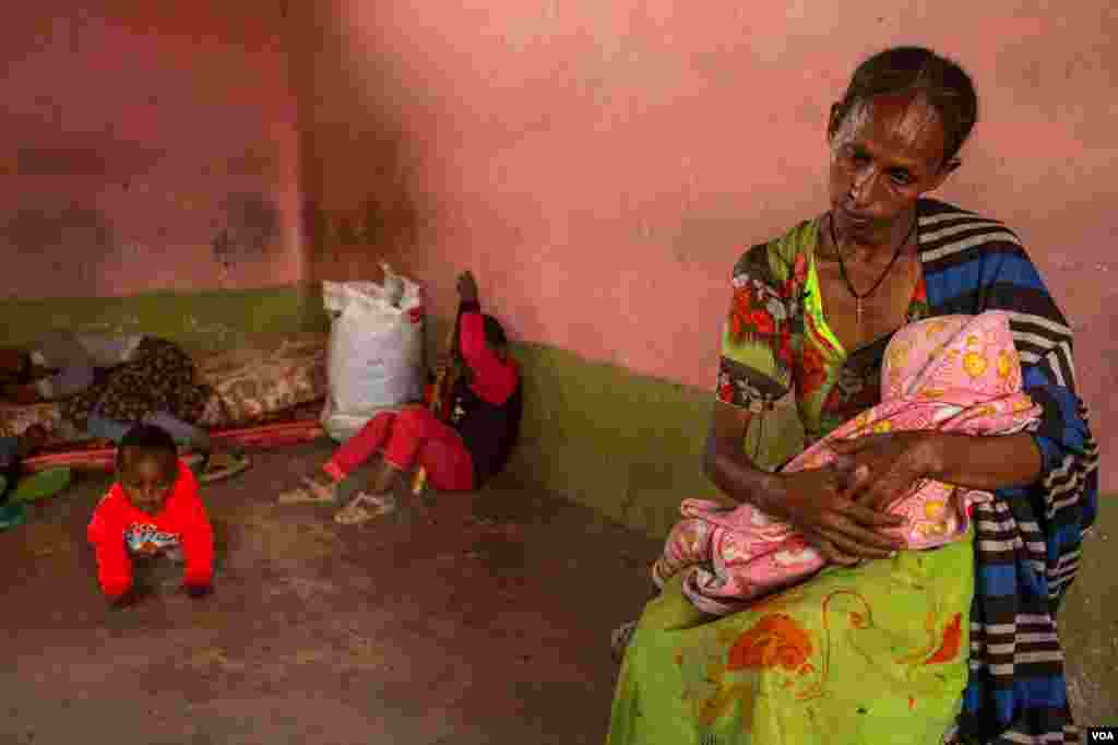A woman sits with her wounded baby in a central Mekelle, Ethiopia, classroom that was turned into housing for displaced people, June 3, 2021.