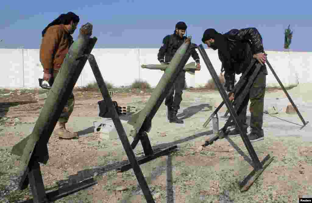 Fighters from the Free Syrian Army's Saif al-Umayyad brigade prepare rockets to be launched towards forces loyal to Syria's President Bashar al-Assad in the eastern Damascus suburb of Ghouta, Jan. 16, 2014.