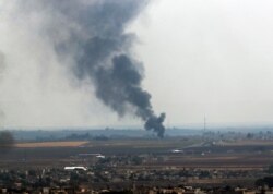 In this photo taken from the Turkish side of the border between Turkey and Syria, in Ceylanpinar, Sanliurfa province, southeastern Turkey, smoke billows from a fire in Ras al-Ayn, Syria, Oct. 20, 2019.