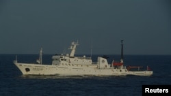 A Chinese marine surveillance ship cruises in waters about 28 km (17 miles) northwest of one of the disputed islands called Senkaku in Japan and Diaoyu in China, in the East China Sea, in this handout photo released by Japan Coast Guard's 11th Regional Co