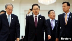 South Korean President Lee Myung-bak (C) is followed by his staff as he leaves the Plenary session of the 21st ASEAN (Association of Southeast Asian Nations) and East Asia summits in Phnom Penh November 20, 2012