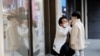 A man and a boy wear masks to prevent contracting a new coronavirus at Myeongdong shopping district in Seoul, South Korea, February 20, 2020. REUTERS/Heo Ran