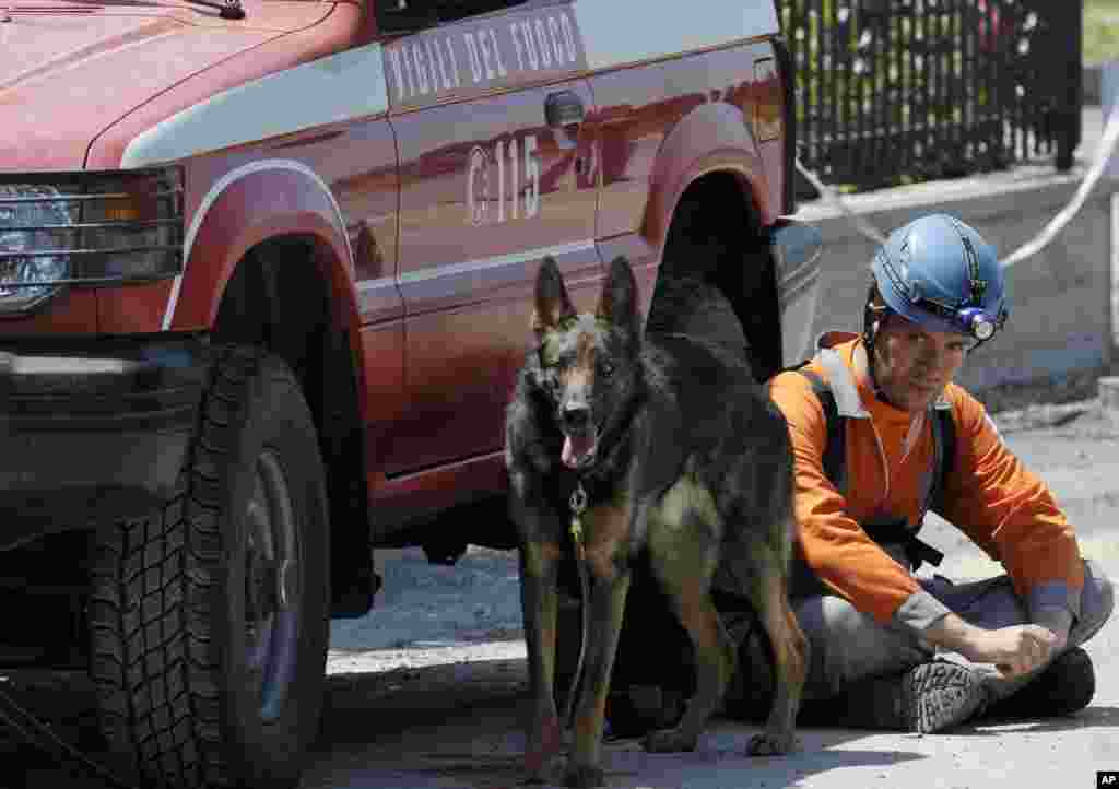 Un bombero italiano, exausto, toma un breve descanso junto a su perro entrenado para buscar supervivientes, durante las tareas de rescate en Cavezzo, en el norte de Italia este martes 29 de mayo de 2012.