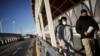 Un migrante es escoltado por un agente del Instituto Nacional de Migración (INM) de México, luego de ser deportado de Estados Unidos, en Ciudad Juárez.